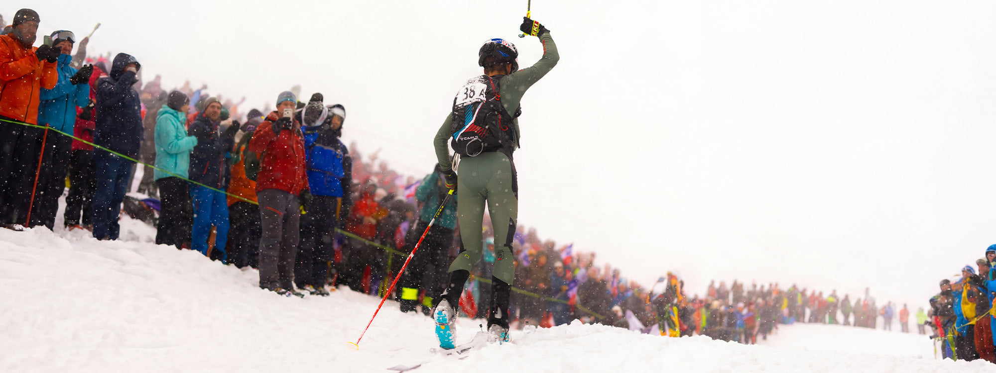 A ski mountaineer competing on a snowy slope wearing SCARPA Alien 5.0 boots.