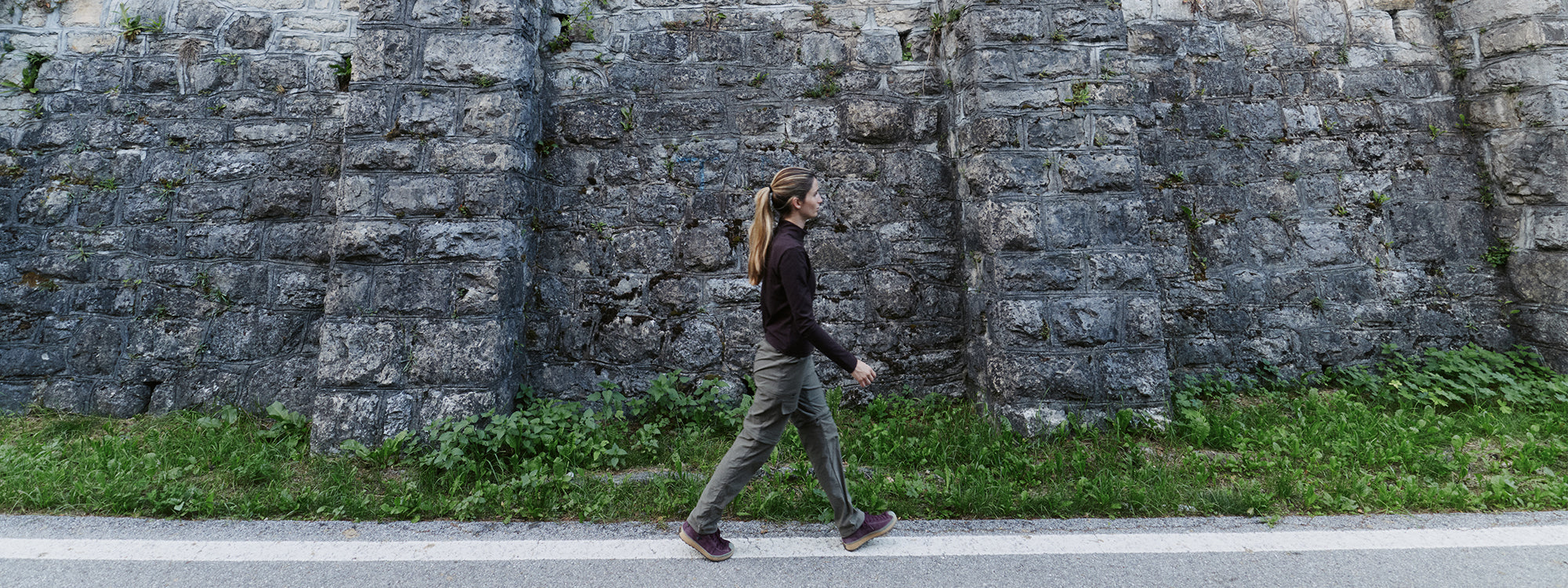 A woman walks along a paved path with SCARPA Mojito Wrap GTX urban lifestyle shoes.