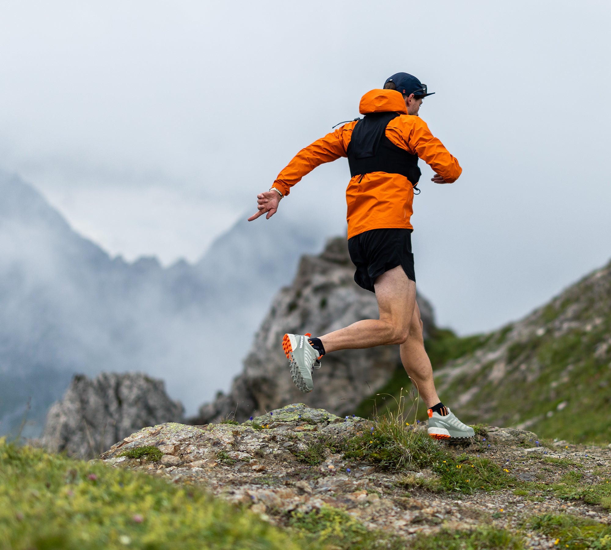 Runner on a mountain trail with mountains in the background with SCARPA's Ribelle Run 2 GTX