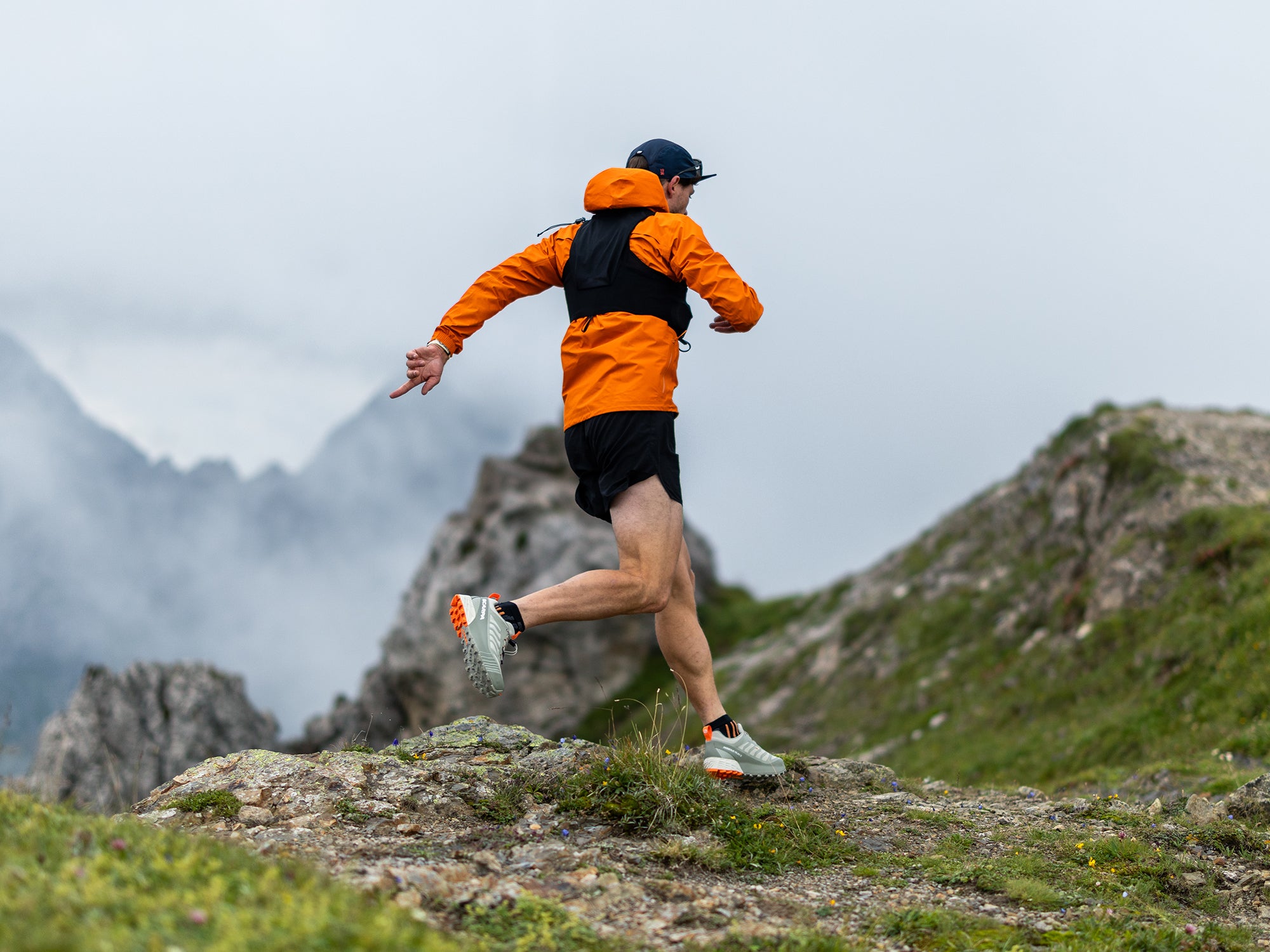 Runner on a mountain trail with mountains in the background with SCARPA's Ribelle Run 2 GTX