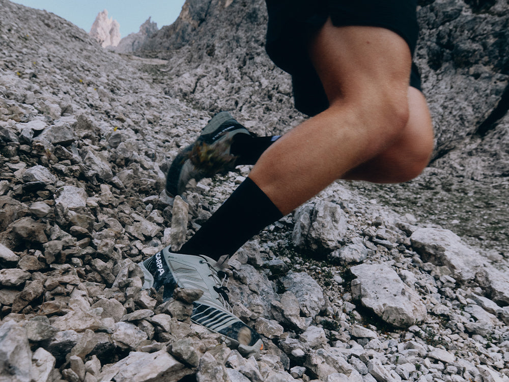 A close-up action shot of a runner's legs while wearing SCARPA Ribelle Run 2 GTX trail running shoes.