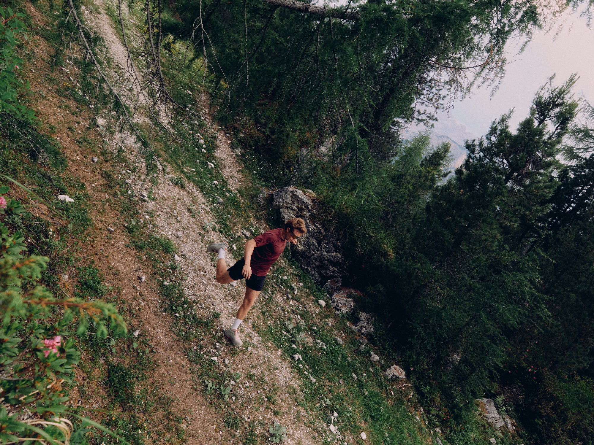 Trail runner on a steep dirt trail wearing SCARPA Spin Planet trail running shoes.