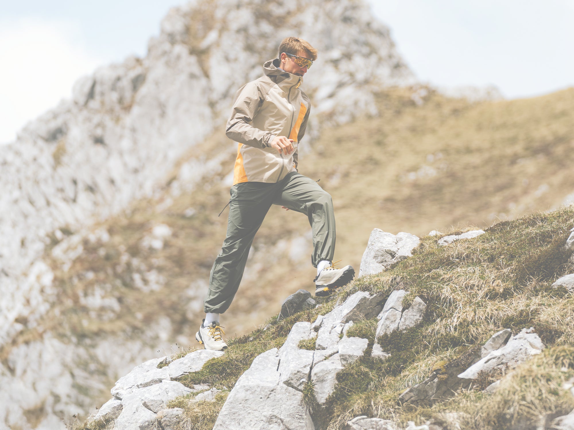 Person hiking on a rocky mountain trail with a backpack wearing SCARPA's Ribelle Cross 2 GTX light hiking boots