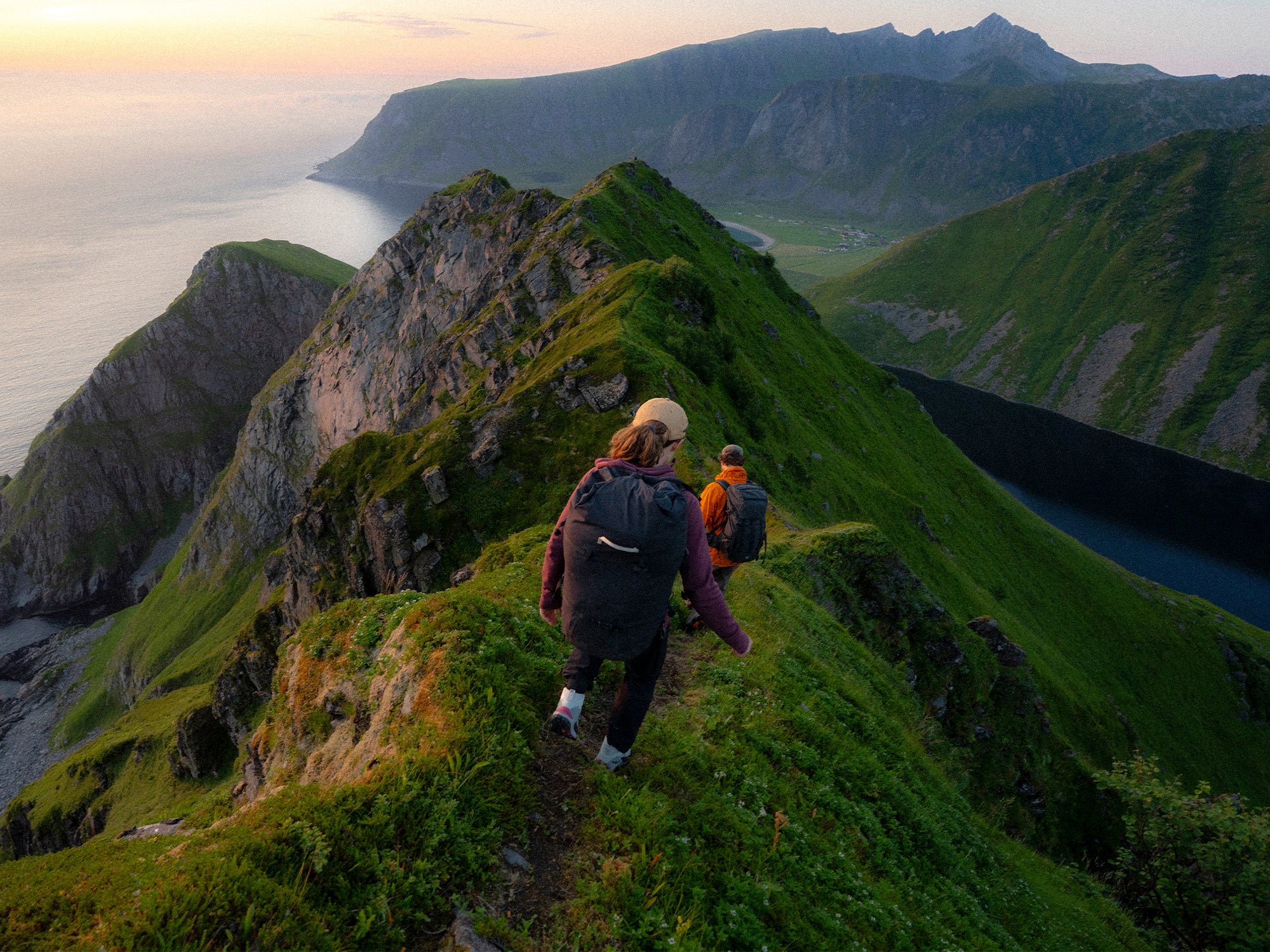Two hikers on a mountain trail with scenic views wearing SCARPA Mustang TRK GTX trekking boots.