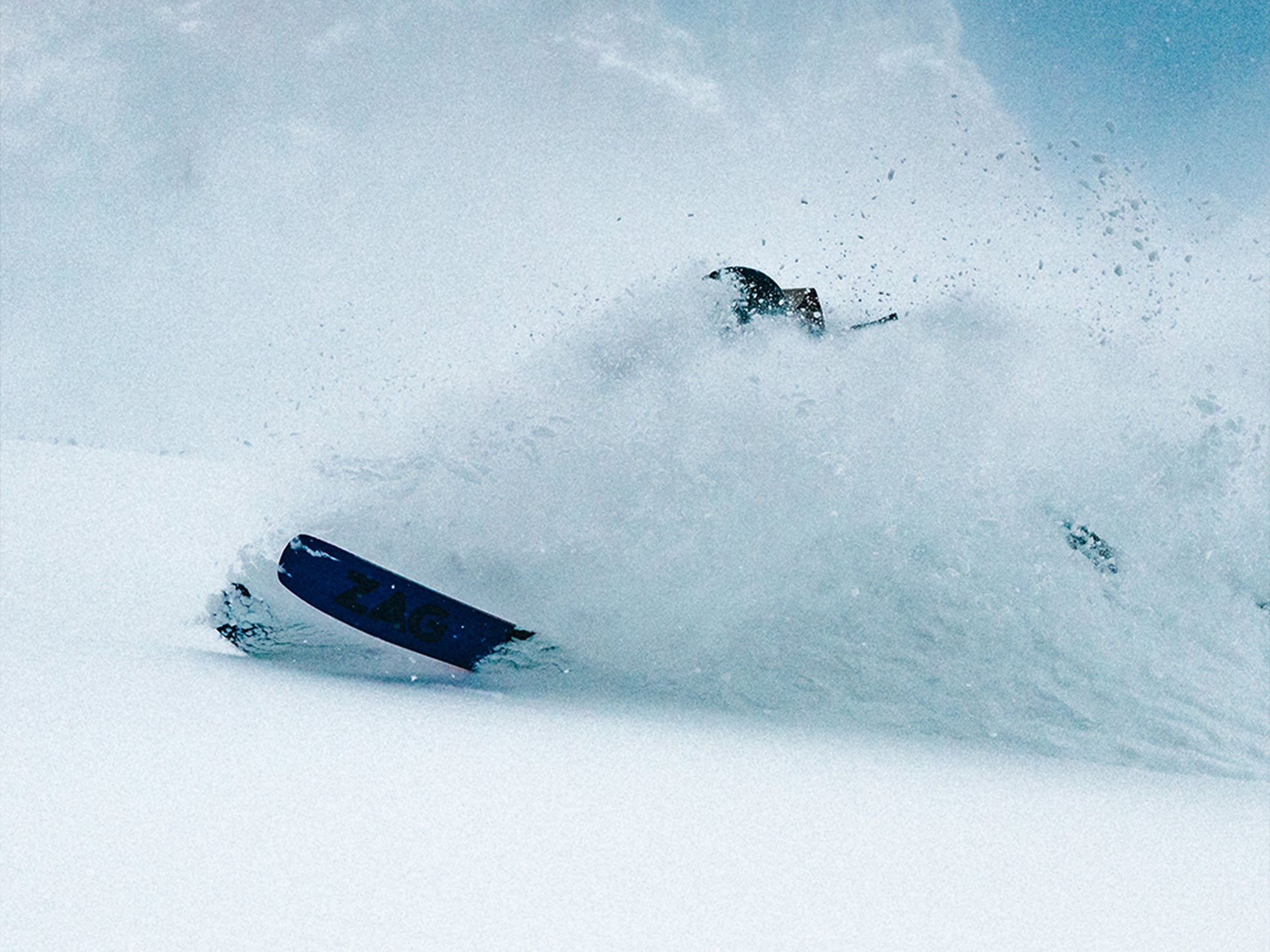 Skier carving through deep powder snow while wearing SCARPA's Gea RS ski mountaineering boots.