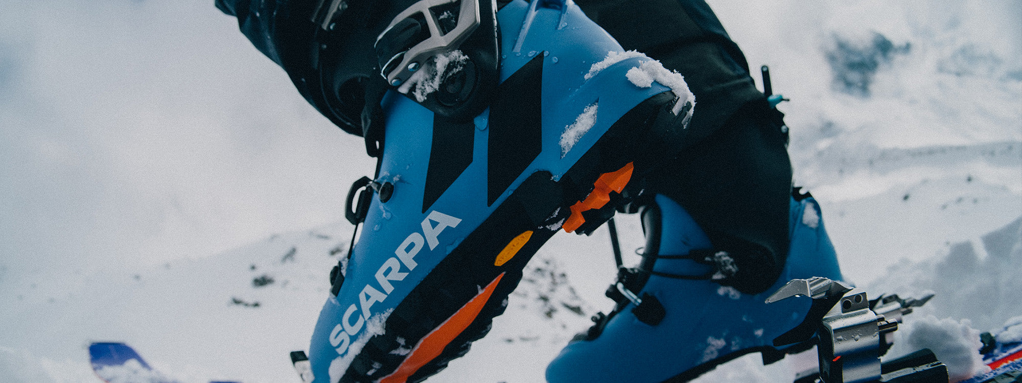 A close-up action shot of a skier wearing SCARPA's Gea ski mountaineering boots.