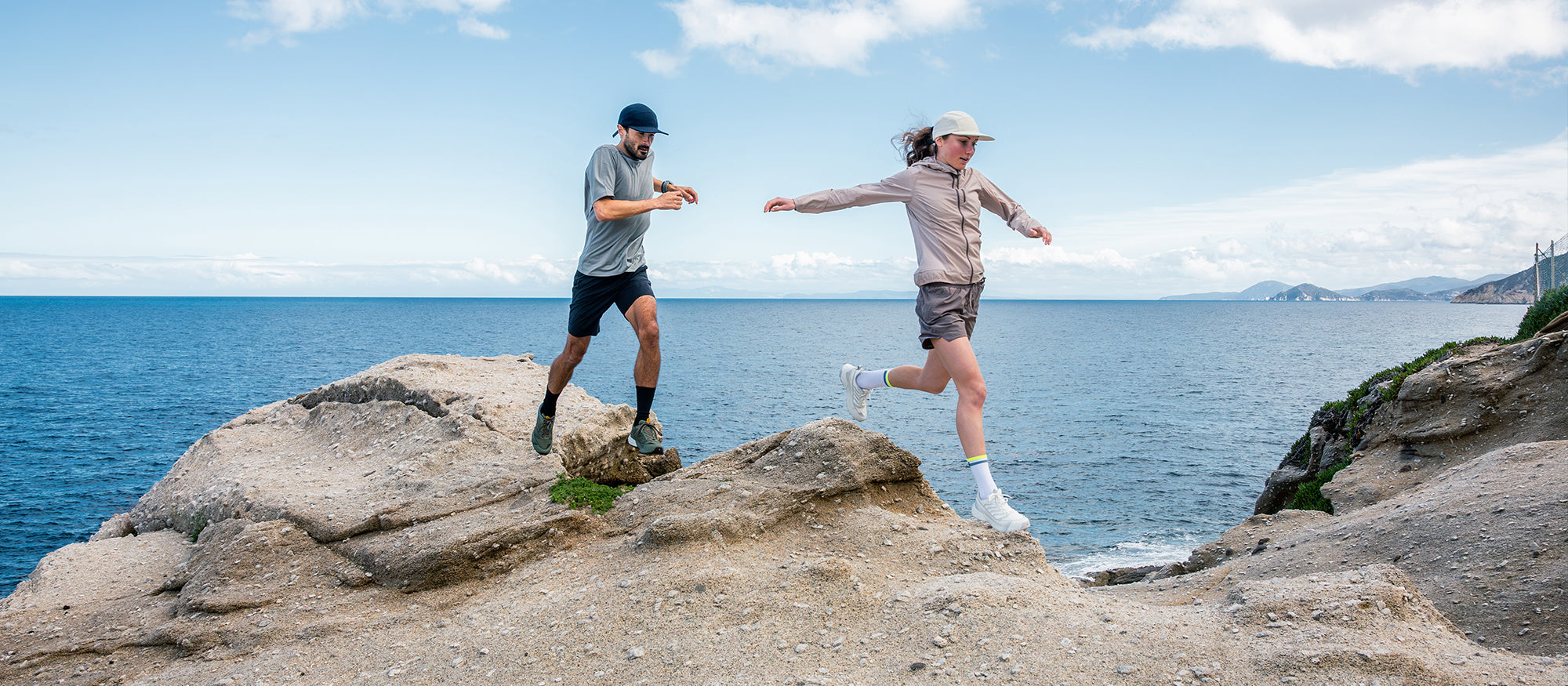 Runners on a rocky shoreline wearing Ribelle Run LT WP