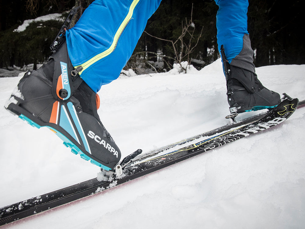 Skier wearing SCARPA Alien ski mountaineering race boots in a snowy landscape