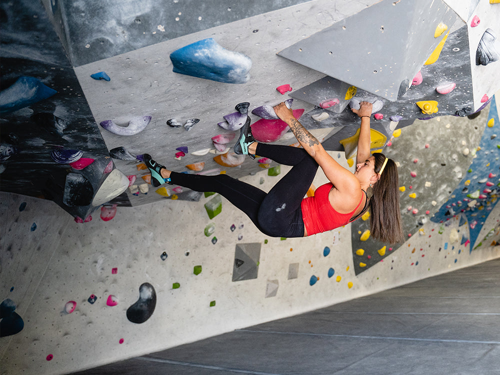 Climber on an indoor rock climbing wall with Arpia V LV