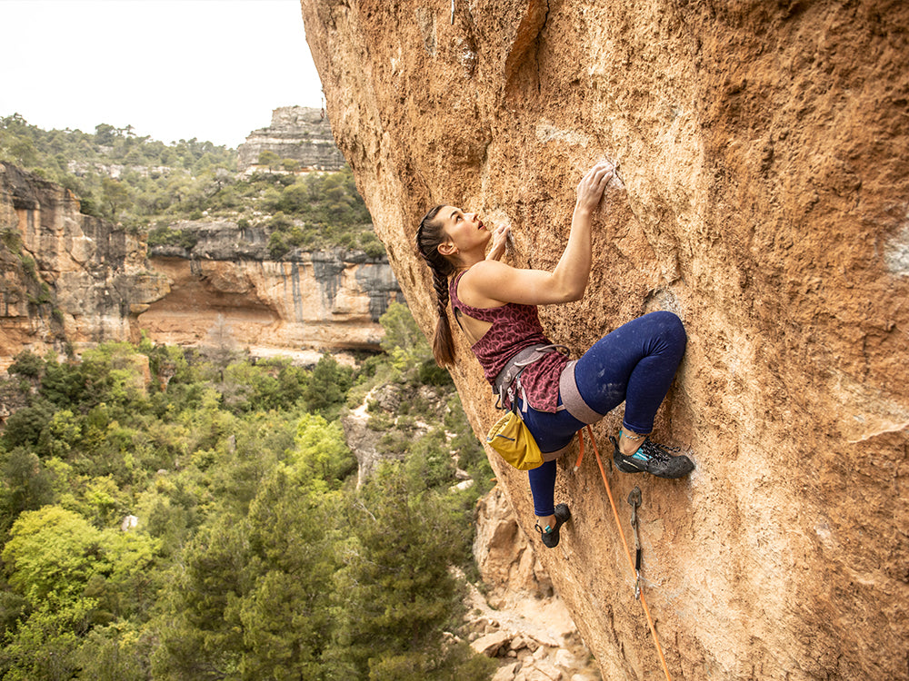 Jenya Kazbekova climbing a rocky cliff with Chimera