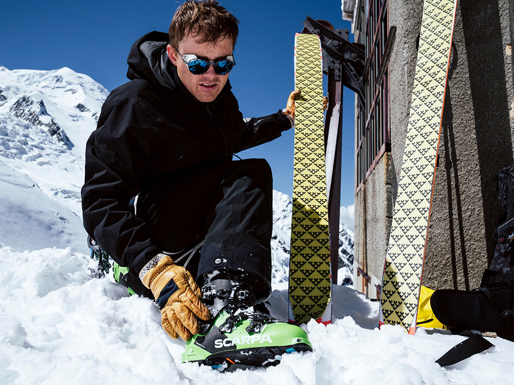 Nikolai Schirmer preparing skis in the snow wearing 4-Quattro Pro