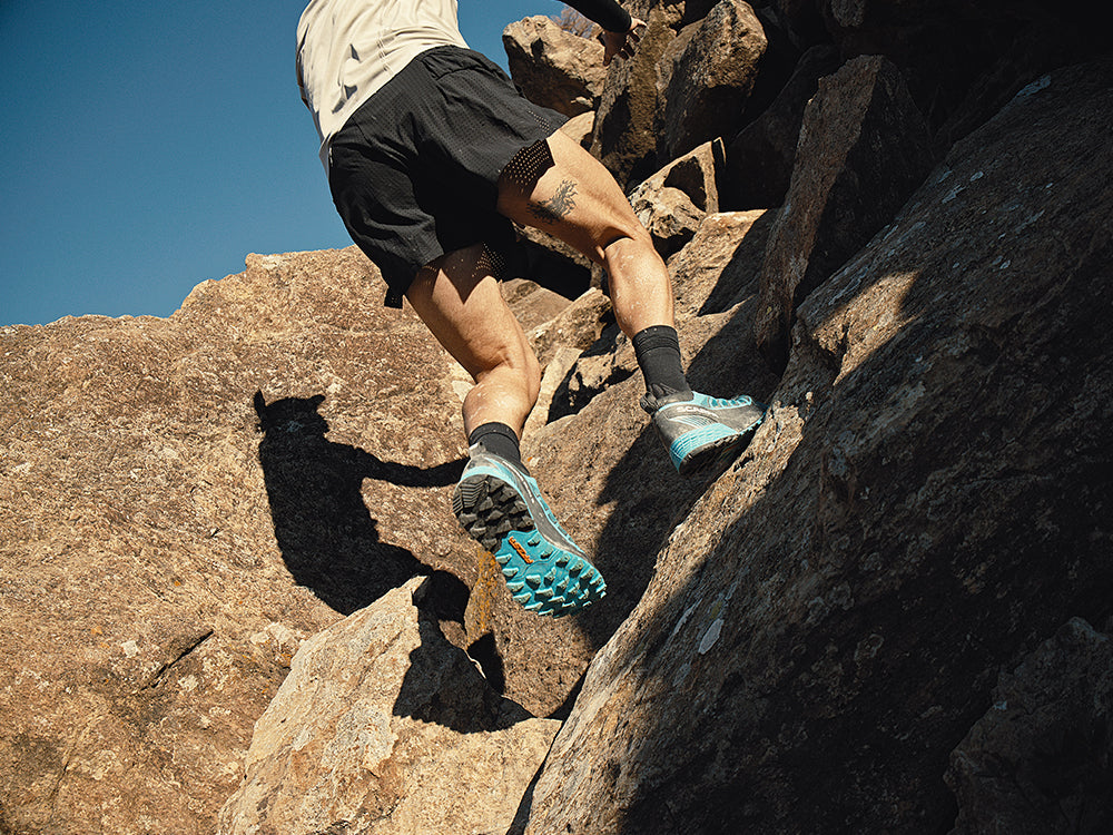 Runner on a mountain path wearing Ribelle Run 2