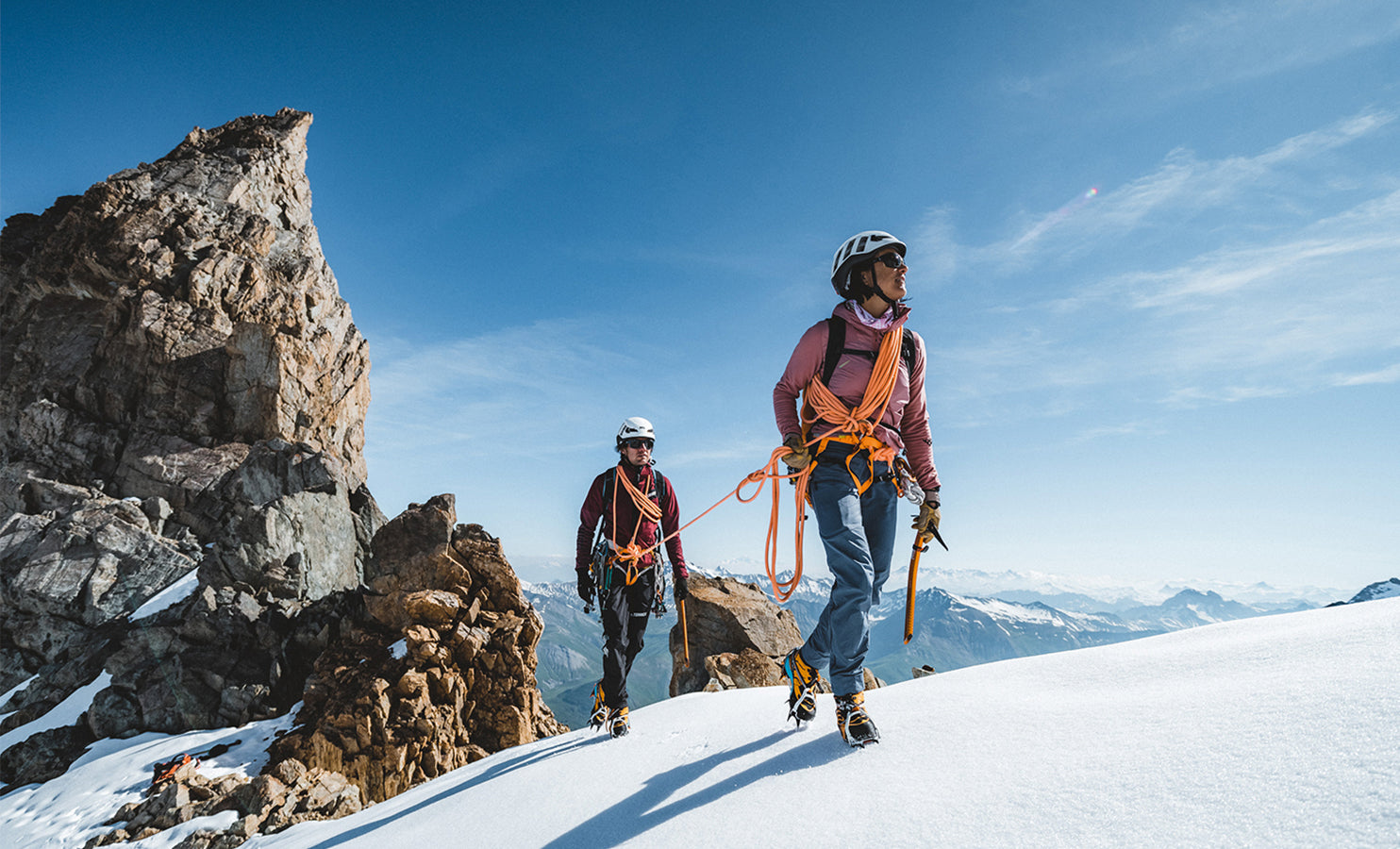 Two climbers on a snowy mountain with clear blue sky wearing SCARPA's mountaineering boots