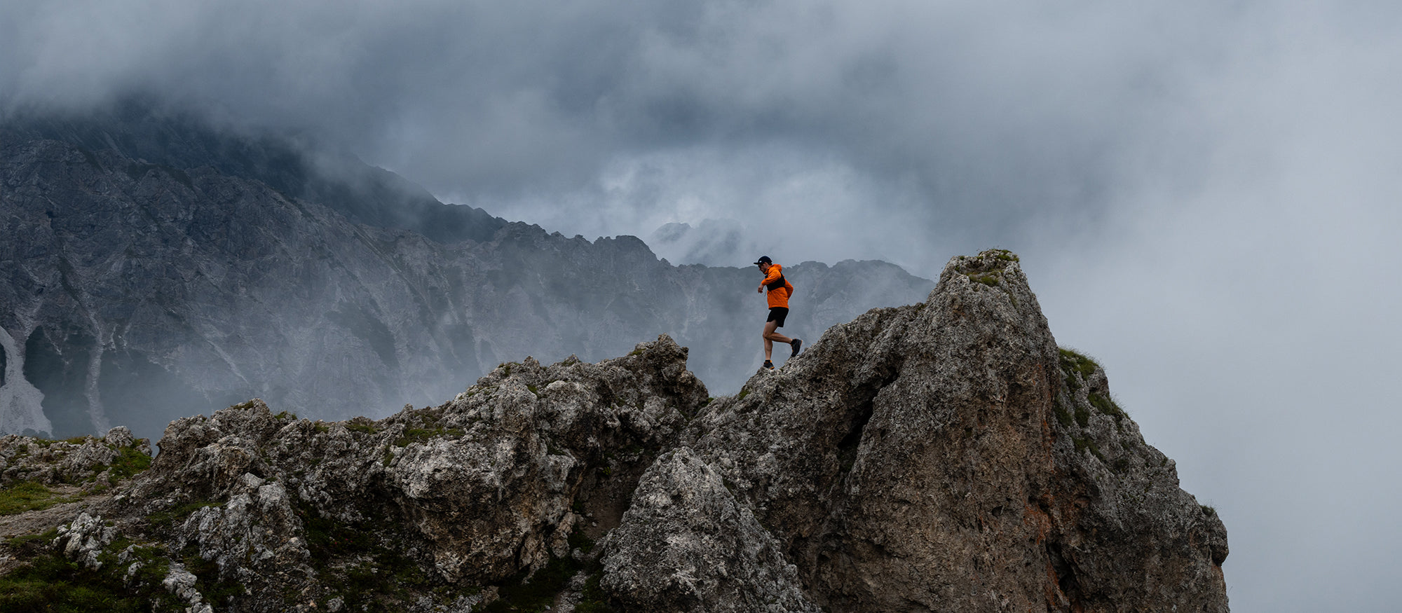 Trail runner standing on a rocky mountain peak with SCARPA Ribelle Run 2 GTX