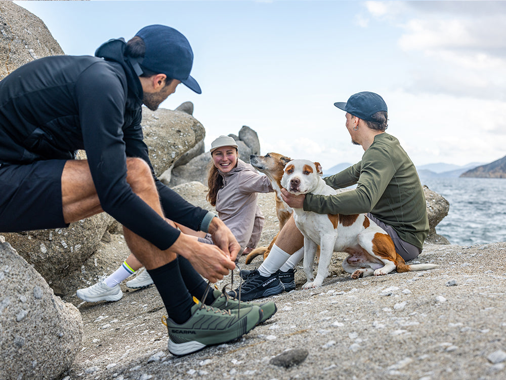 Runners resting on the rocks wearing Ribelle Run LT WP