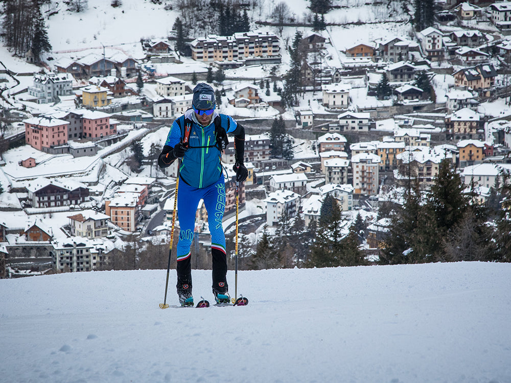 Mattero Eydallin skiing wearing Alien 4.0 with a snowy village in the background